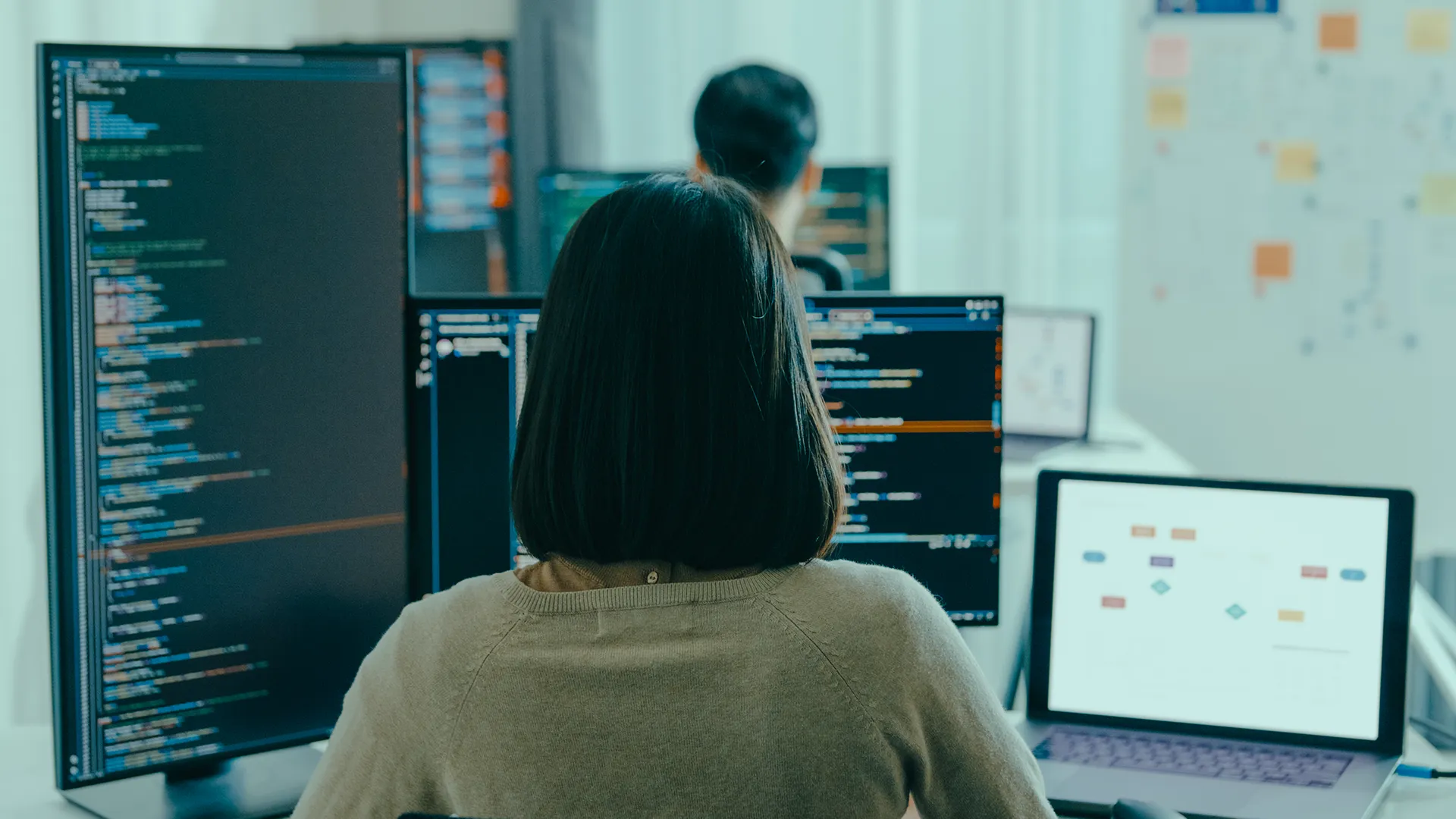 Codezilla specialist working on digital project development across multiple screens in a modern office