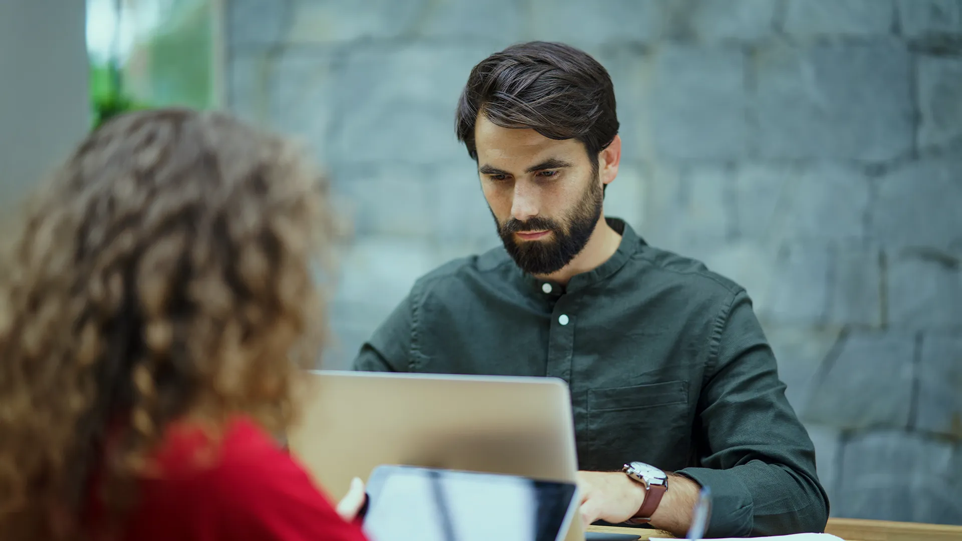 Developer working with focus on a laptop in a professional setting that suggests learning and continuous development