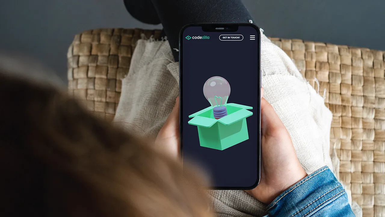 Digital innovation concept displayed on a smartphone screen, featuring a light bulb emerging from a box, symbolizing AI-driven software development