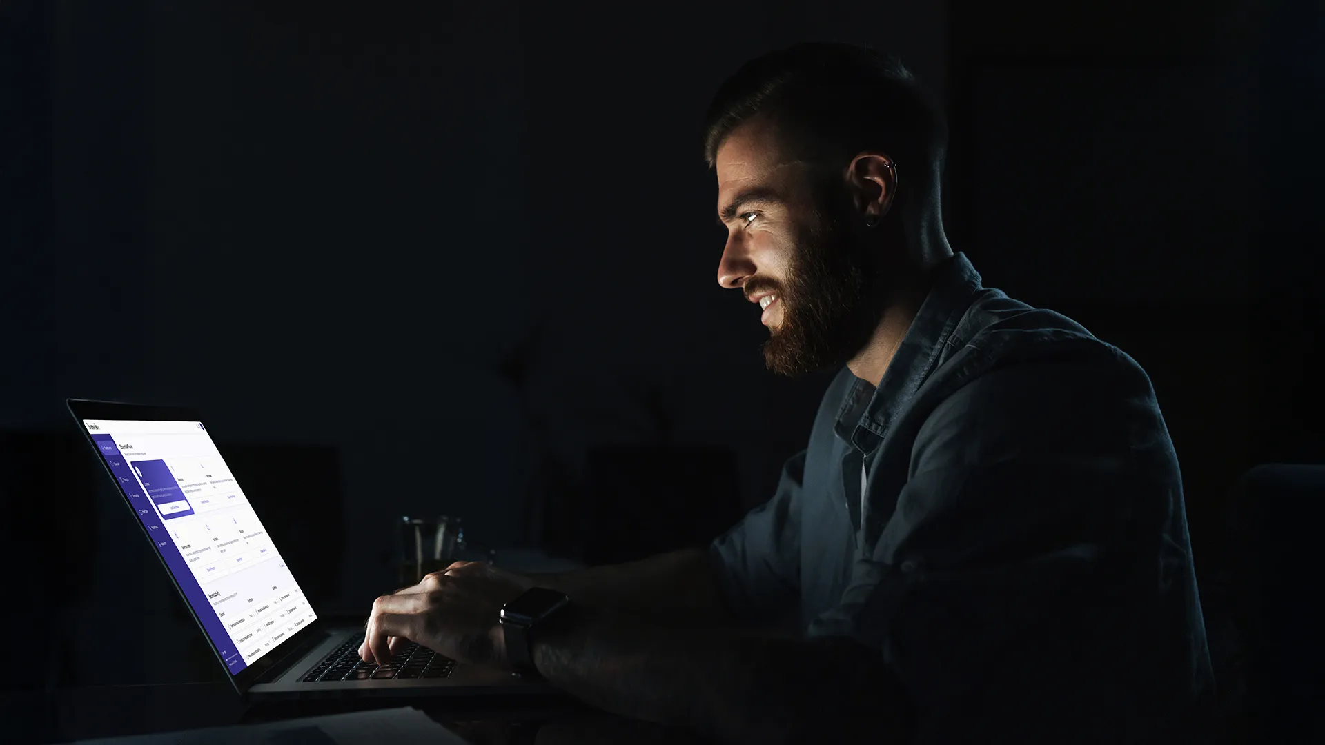 Man working on a laptop in a dark office, using the Benvolio platform for AI-assisted legal and tax analysis