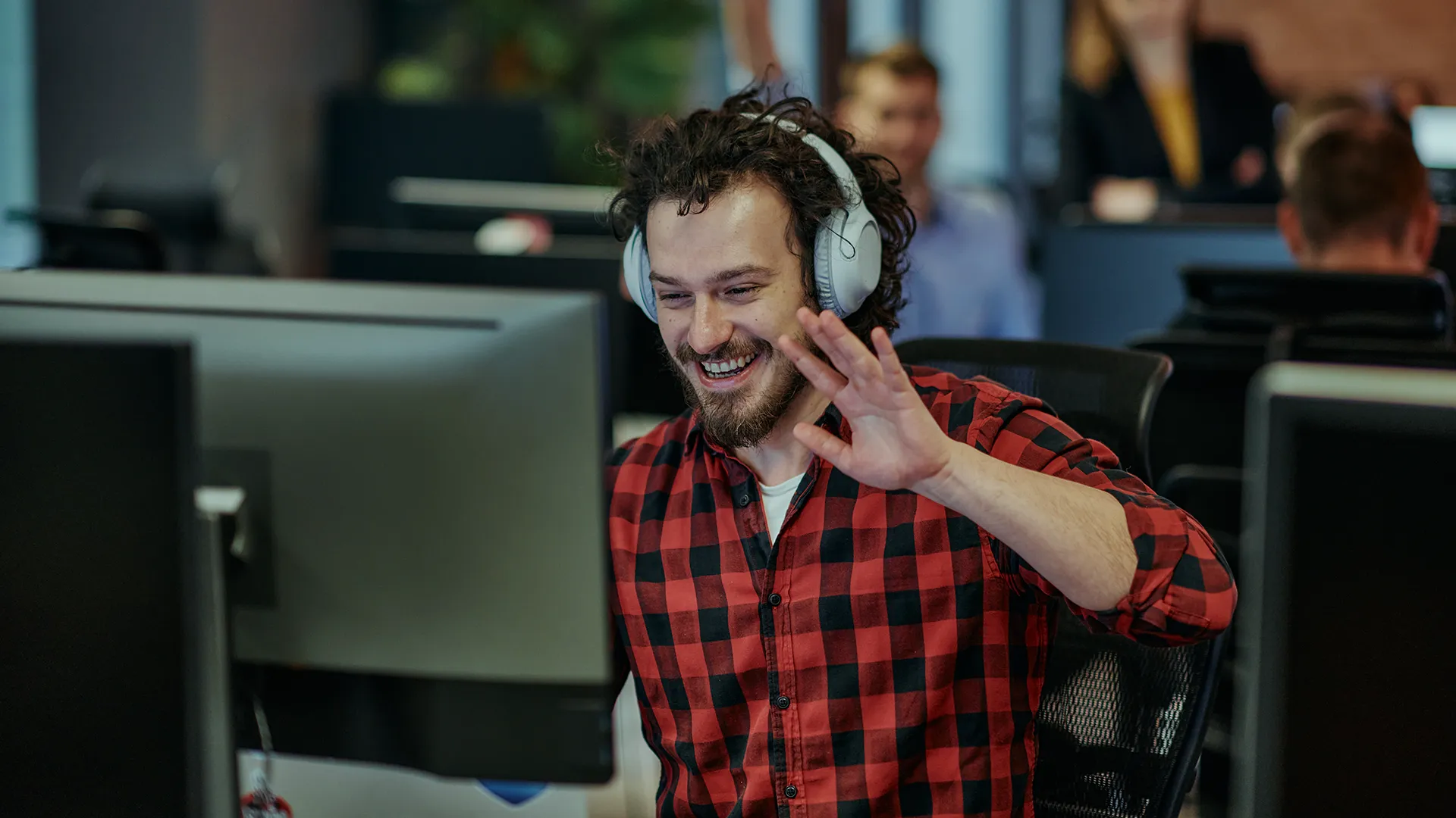 Programator participând la o întâlnire video de la birou, într-un mediu de lucru colaborativ