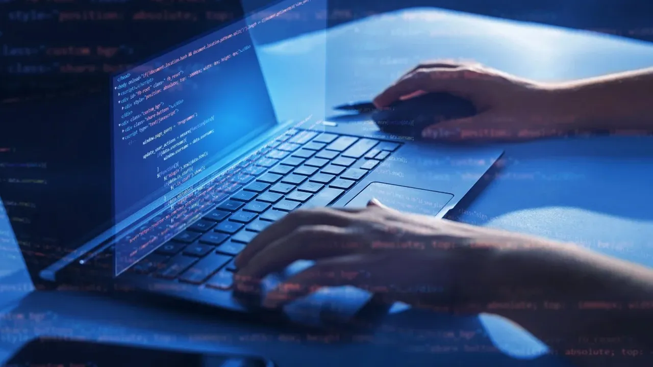 Programator concentrat la un ecran cu cod, pe fundal albastru