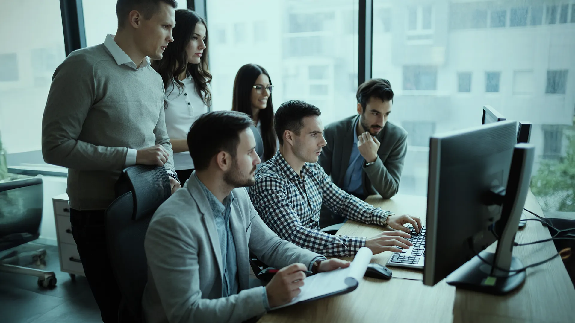 Team reviewing information together on screen in a collaborative workspace within a modern office